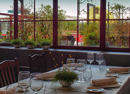 Un rincón del restaurante La Dársena, con la terraza y al fondo el Centro Niemeyer